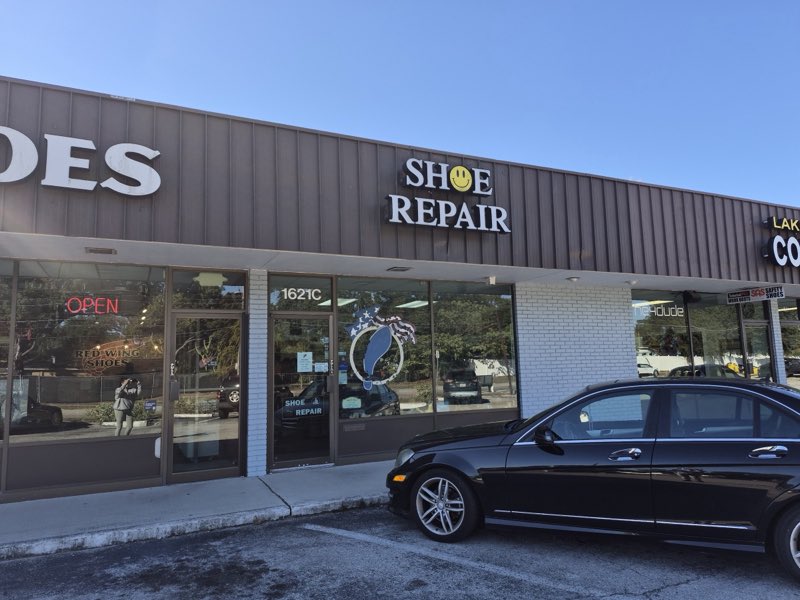 Edgewood Drive Shoe Repair storefront from the parking lot showing the SHOE REPAIR sign, red OPEN neon and the 1621C entrance